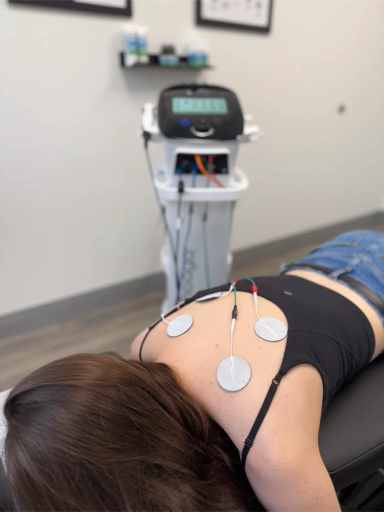 Photo of a woman undergoing electrical muscle stimulation. Discover the benefits of dry needling when combined with EMS. Visit a dry needling chiropractor in Jupiter, FL, to find out if this approach is right for you.